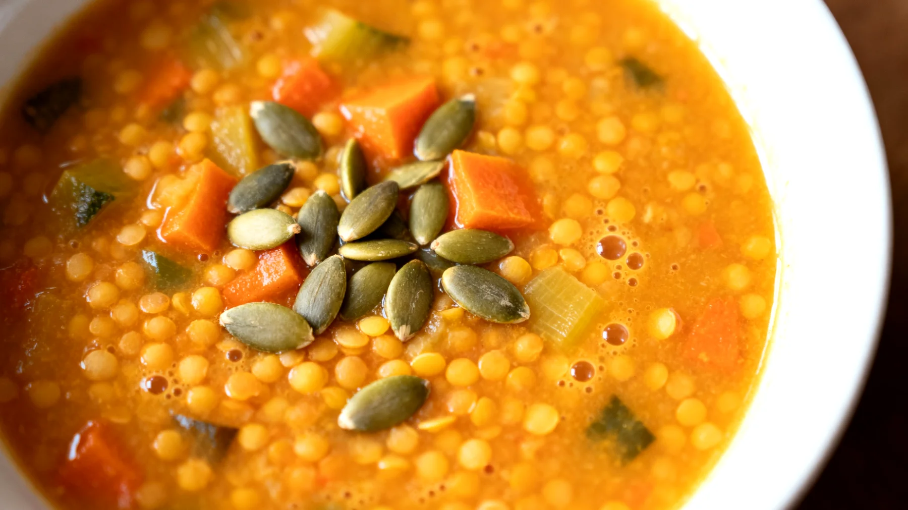 Zuppa di lenticchie rosse decorticate con verdure e semi di zucca"